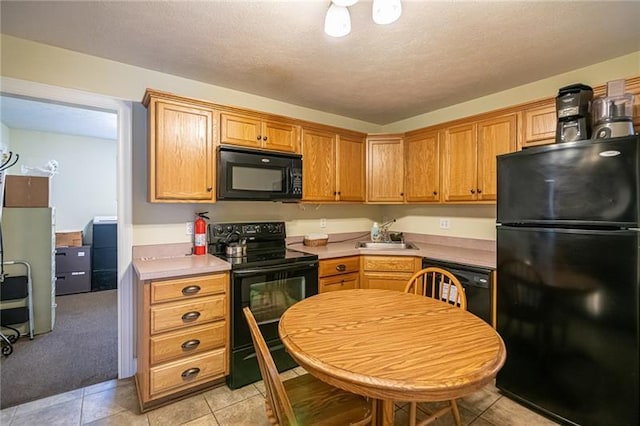 kitchen featuring sink, light carpet, and black appliances