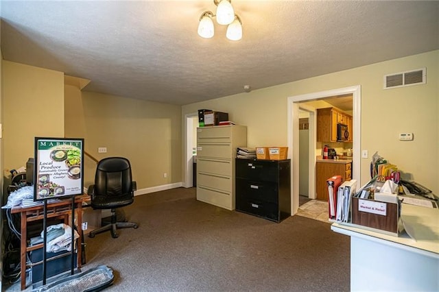 carpeted office featuring a textured ceiling