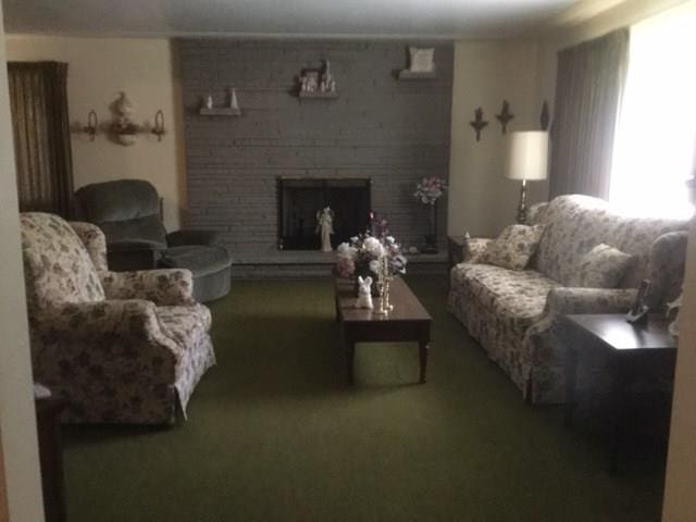 carpeted living room with brick wall and a fireplace