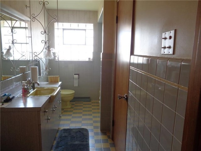 bathroom with large vanity, tile walls, tile flooring, and toilet