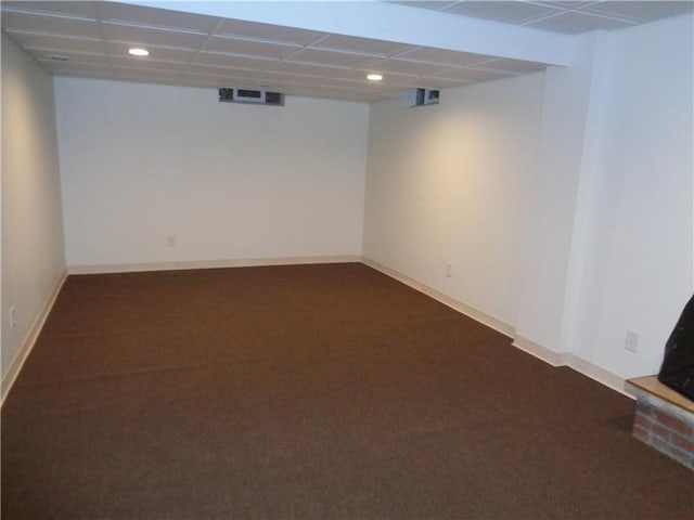 basement with dark carpet and a drop ceiling