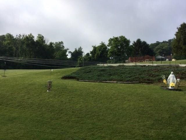 view of home's community with a rural view and a lawn