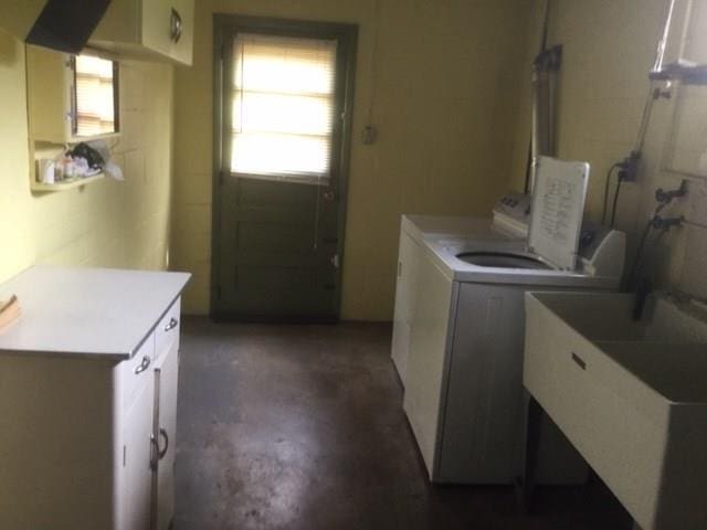 laundry area featuring separate washer and dryer, cabinets, and sink