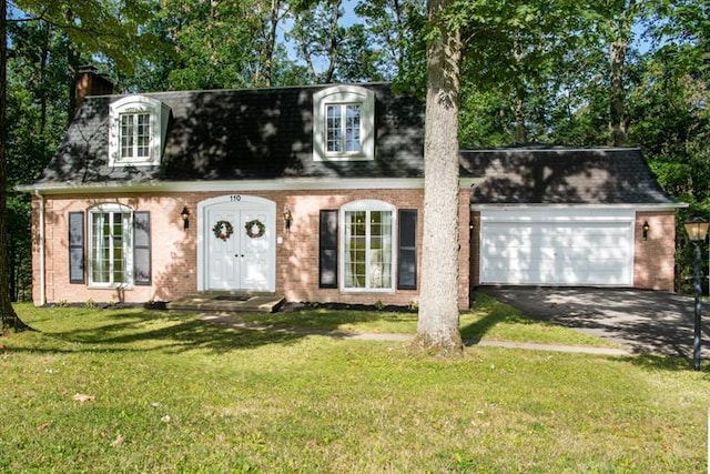 cape cod home featuring a front lawn and a garage