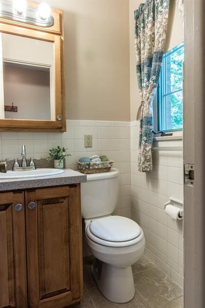 bathroom featuring tile walls, toilet, tile floors, tasteful backsplash, and vanity