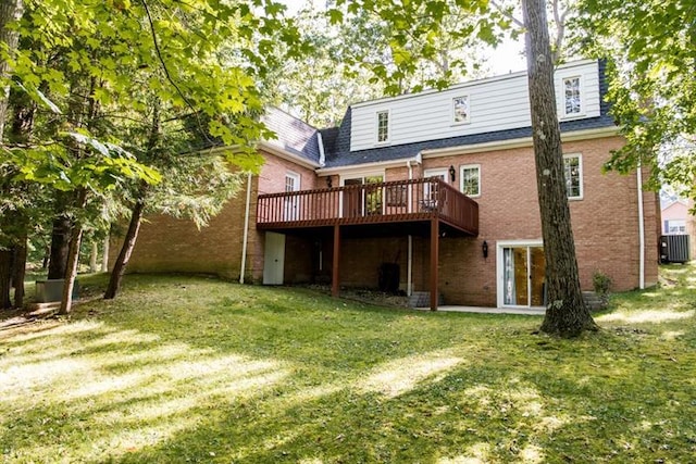 rear view of property with central AC unit, a wooden deck, and a yard