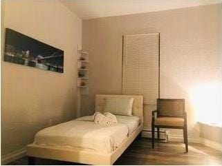 bedroom with dark wood-type flooring