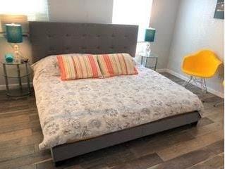 bedroom featuring multiple windows and dark wood-type flooring