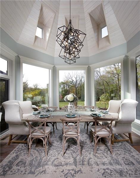 sunroom featuring vaulted ceiling with skylight and a wealth of natural light