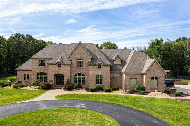 french provincial home with a front yard