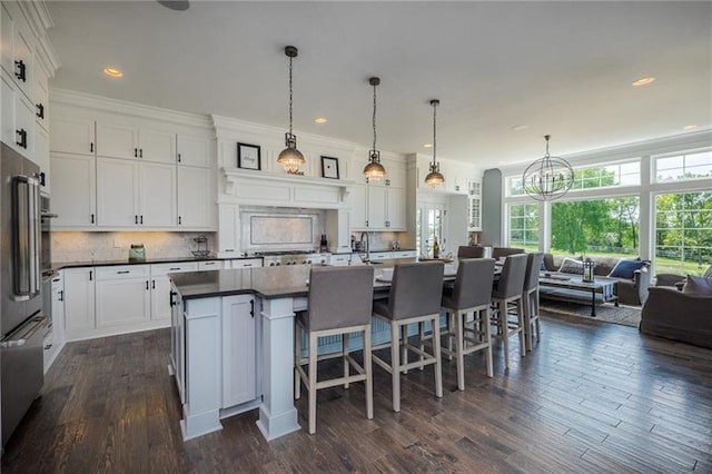 kitchen with an inviting chandelier, hanging light fixtures, dark hardwood / wood-style flooring, and white cabinets