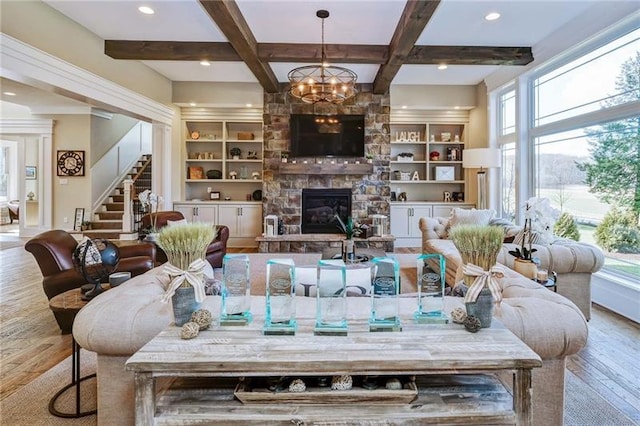 living room featuring coffered ceiling, a fireplace, light hardwood / wood-style floors, beam ceiling, and a chandelier