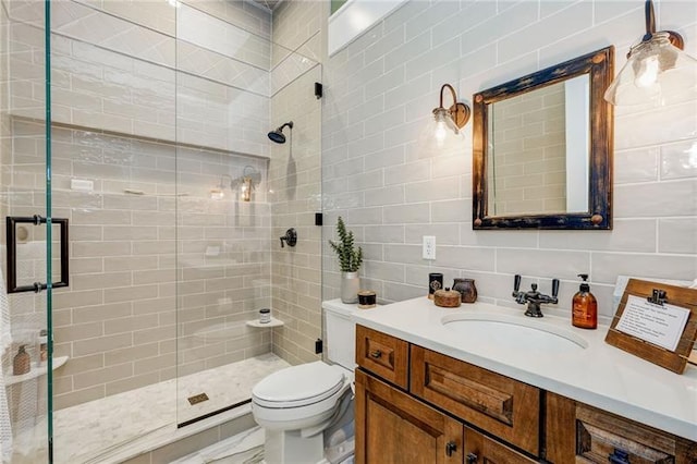 bathroom with tile walls, backsplash, a shower with door, toilet, and vanity