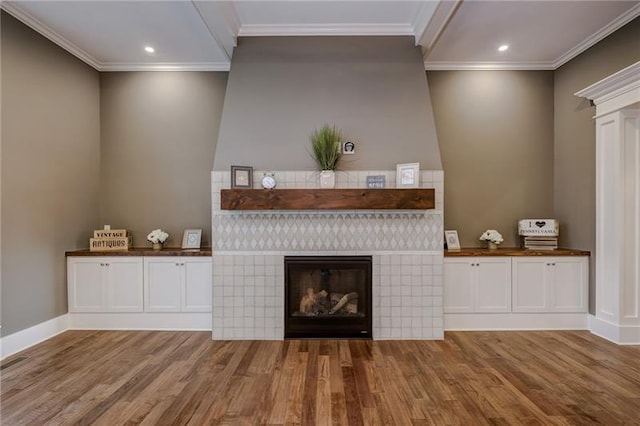 unfurnished living room with a fireplace, crown molding, and hardwood / wood-style flooring