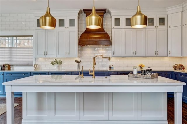 kitchen with blue cabinets, backsplash, a breakfast bar, and dark hardwood / wood-style flooring