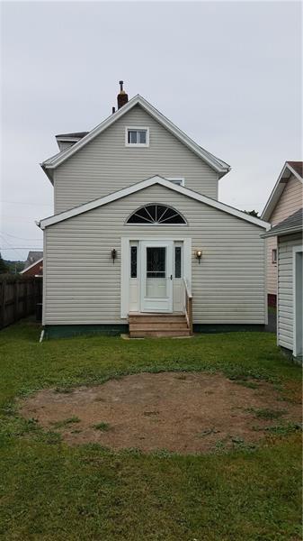 back of property featuring a yard