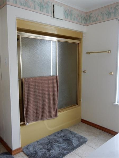 bathroom featuring bath / shower combo with glass door and tile flooring