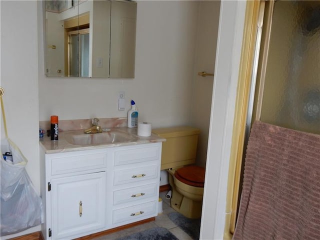 bathroom featuring tile floors, toilet, and vanity