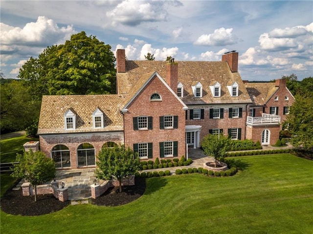 rear view of house with a yard and a patio