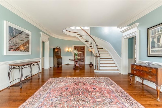 foyer with dark hardwood / wood-style flooring, decorative columns, and ornamental molding