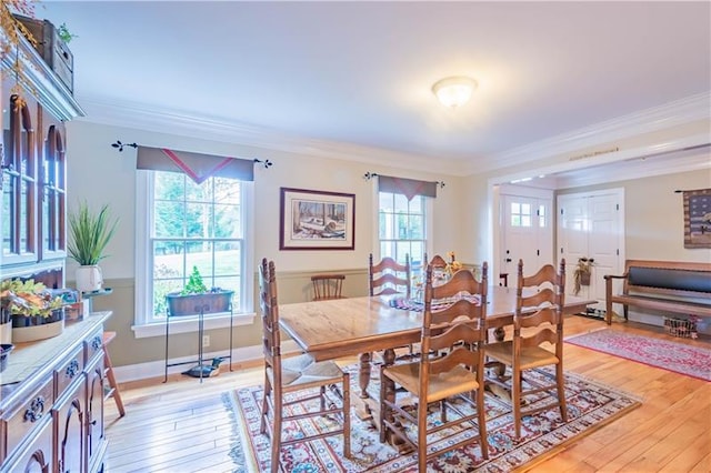 dining space with crown molding and light hardwood / wood-style flooring