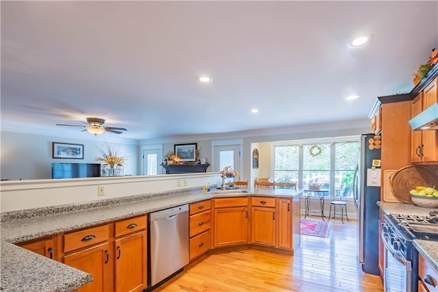 kitchen with stainless steel appliances, ceiling fan, sink, light wood-type flooring, and light stone counters