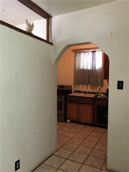 kitchen featuring stove, sink, and light tile flooring