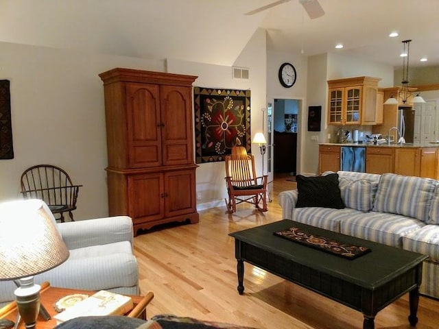 living room featuring high vaulted ceiling, light hardwood / wood-style floors, and ceiling fan