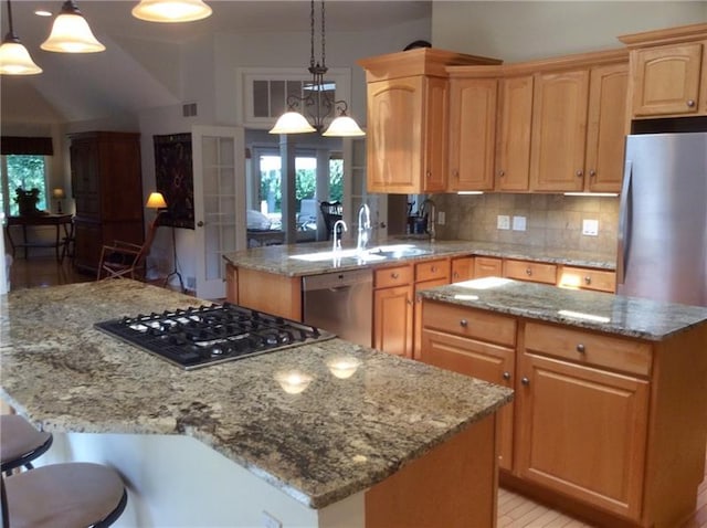 kitchen with a kitchen island, hanging light fixtures, dishwasher, backsplash, and light stone countertops