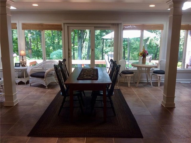 dining area featuring dark tile floors and decorative columns