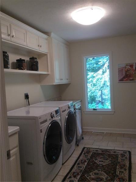 laundry area with washing machine and clothes dryer, cabinets, light tile flooring, and hookup for an electric dryer