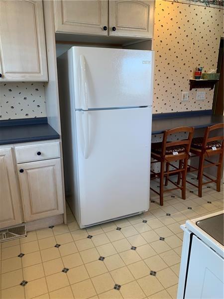 kitchen with white appliances and light tile flooring