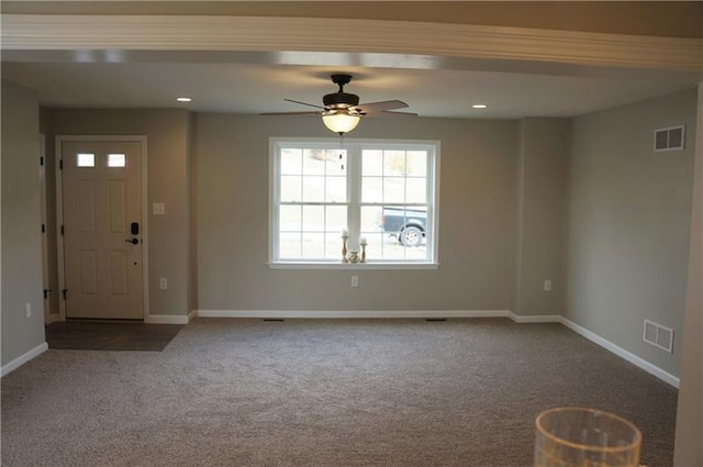 spare room featuring dark colored carpet and ceiling fan