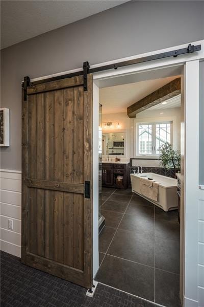 interior space featuring a barn door and dark tile floors