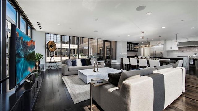 living room featuring expansive windows, dark wood-type flooring, and sink