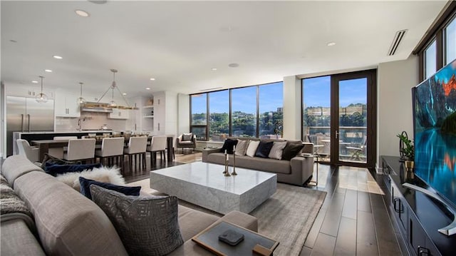 living room featuring floor to ceiling windows, a healthy amount of sunlight, and light wood-type flooring