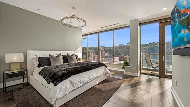 bedroom with a notable chandelier, access to outside, and dark wood-type flooring