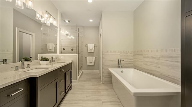 bathroom with dual bowl vanity, tile walls, plus walk in shower, and tile floors