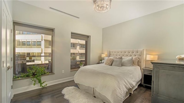 bedroom featuring an inviting chandelier and dark wood-type flooring