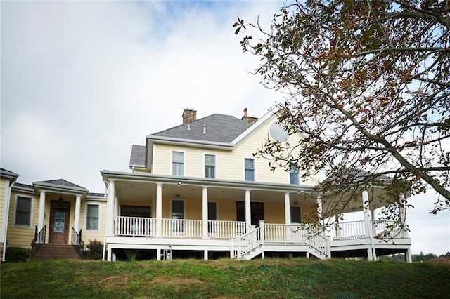 back of property featuring covered porch and a yard