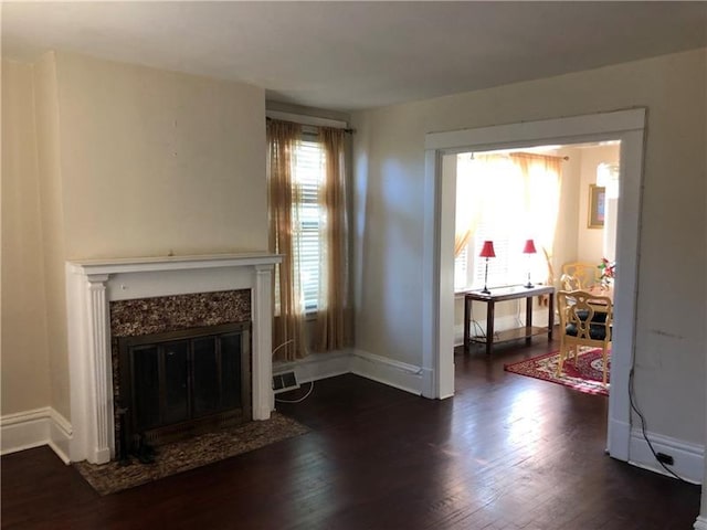 living room with dark hardwood / wood-style flooring, a fireplace, and plenty of natural light