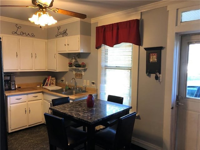 kitchen with white cabinets, crown molding, ceiling fan, and sink