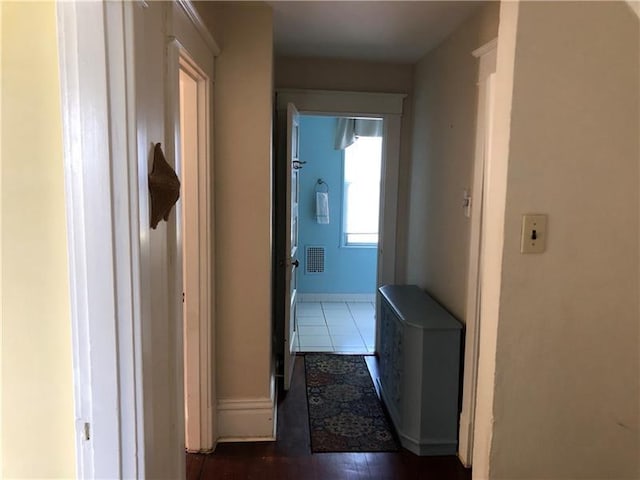 hall with dark tile flooring