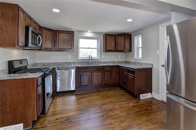 kitchen featuring dark hardwood / wood-style floors, appliances with stainless steel finishes, dark brown cabinetry, and sink