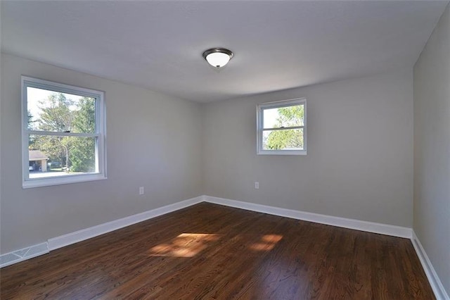 spare room with dark wood-type flooring