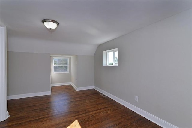 additional living space featuring lofted ceiling and dark wood-type flooring