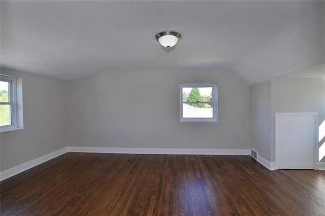 bonus room featuring lofted ceiling, dark wood-type flooring, and a healthy amount of sunlight