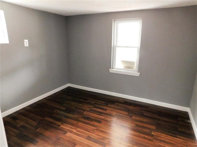 spare room featuring dark wood-type flooring and a wealth of natural light