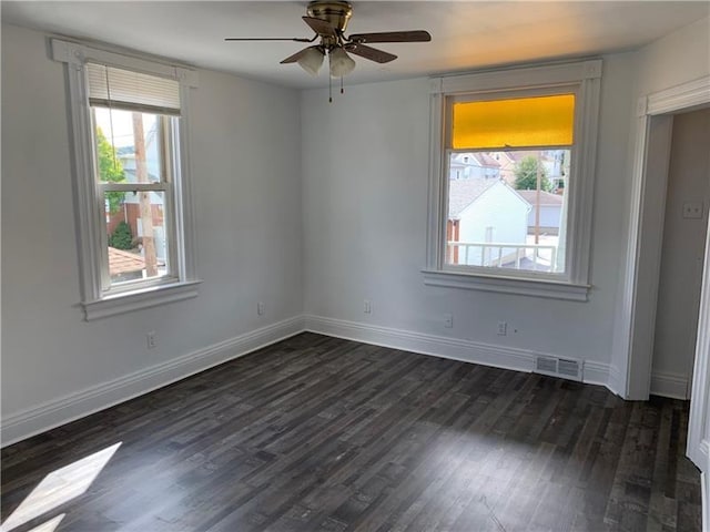 empty room with ceiling fan and dark hardwood / wood-style flooring