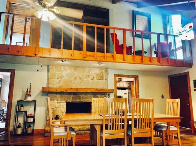 dining space featuring dark hardwood / wood-style flooring, ceiling fan, and a fireplace